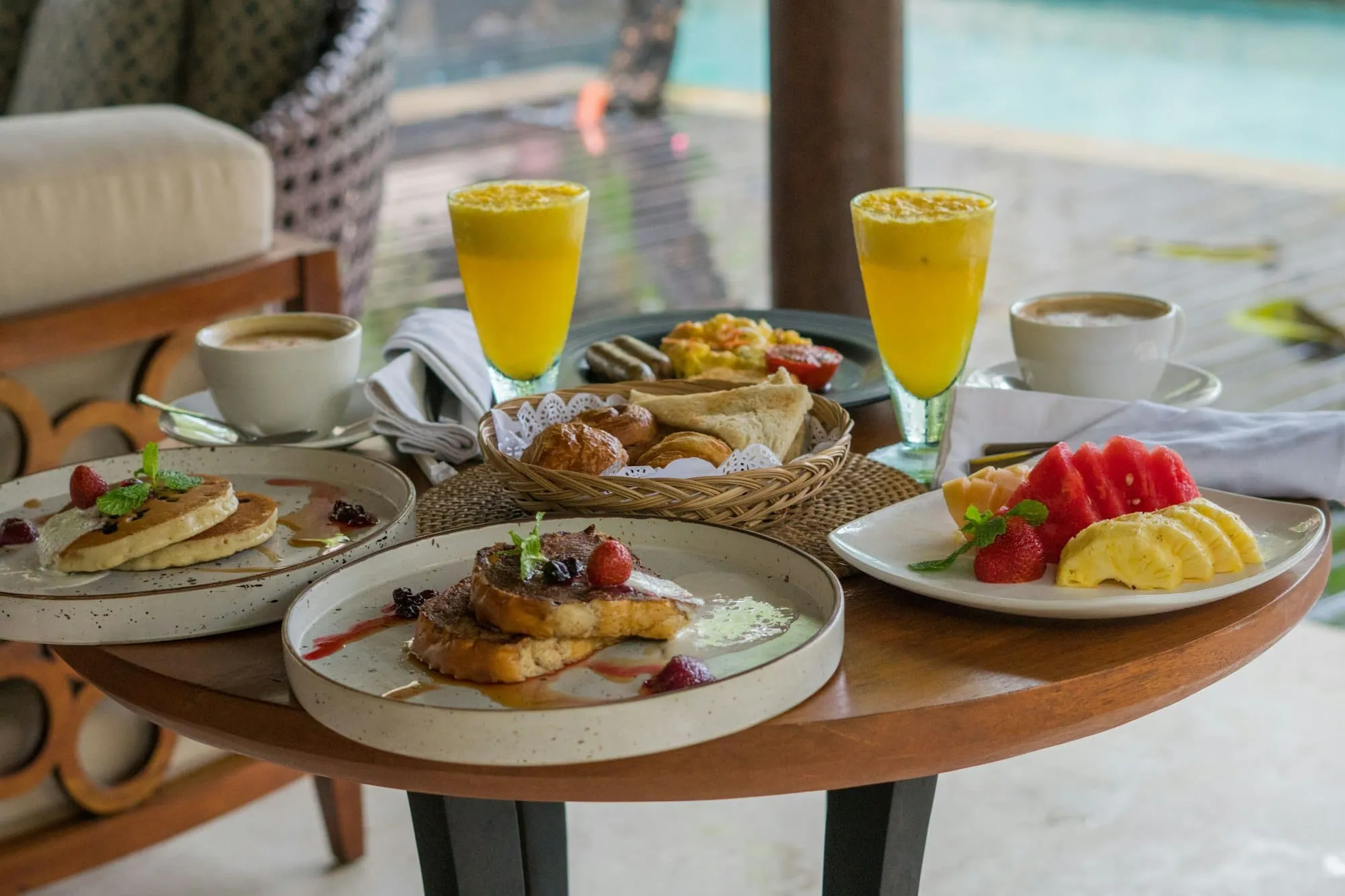 Mesa de madera con desayuno, jugos y café